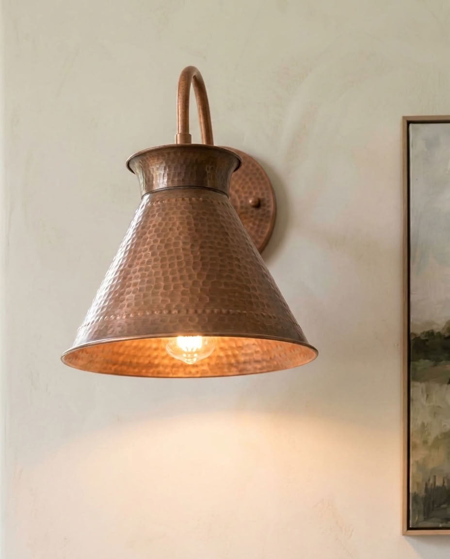 Hammered copper cone wall sconce with curved arm and warm ambient light — view 2