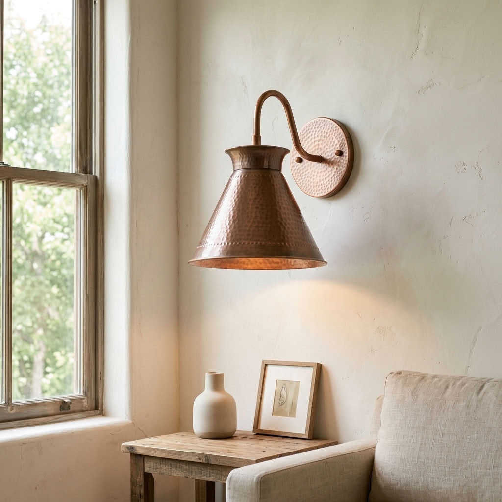 Hammered copper cone wall sconce with curved arm and warm ambient light — view 4