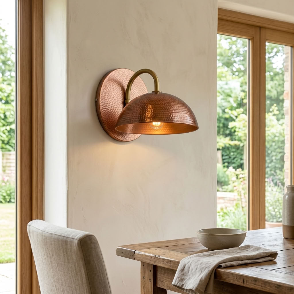 Hammered copper dome wall sconce with curved arm and warm ambient light — view 2