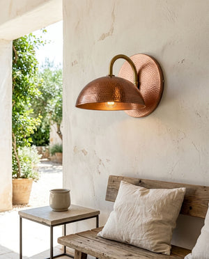 Hammered copper dome wall sconce with curved arm and warm ambient light — view 3