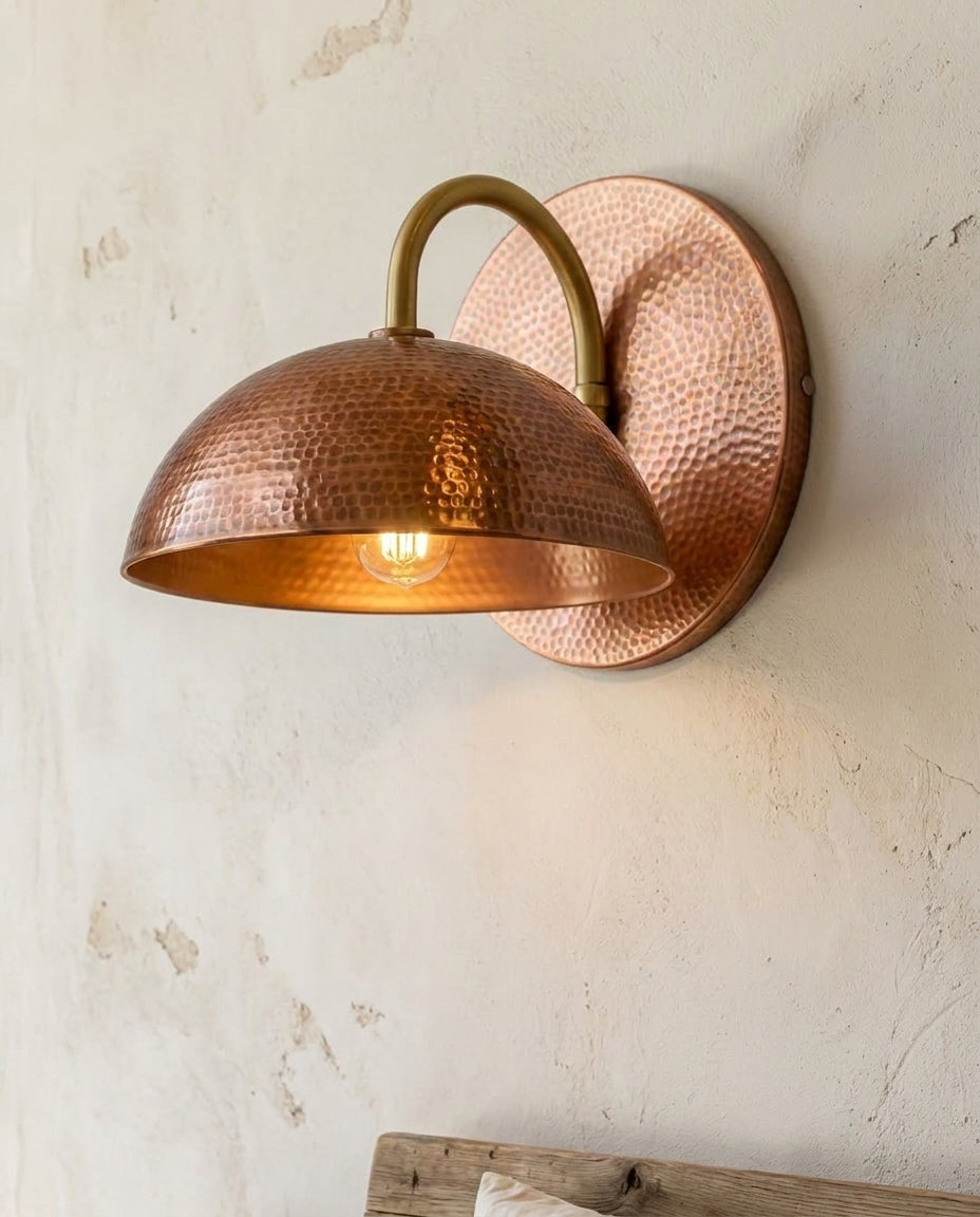 Hammered copper dome wall sconce with curved arm and warm ambient light — view 4