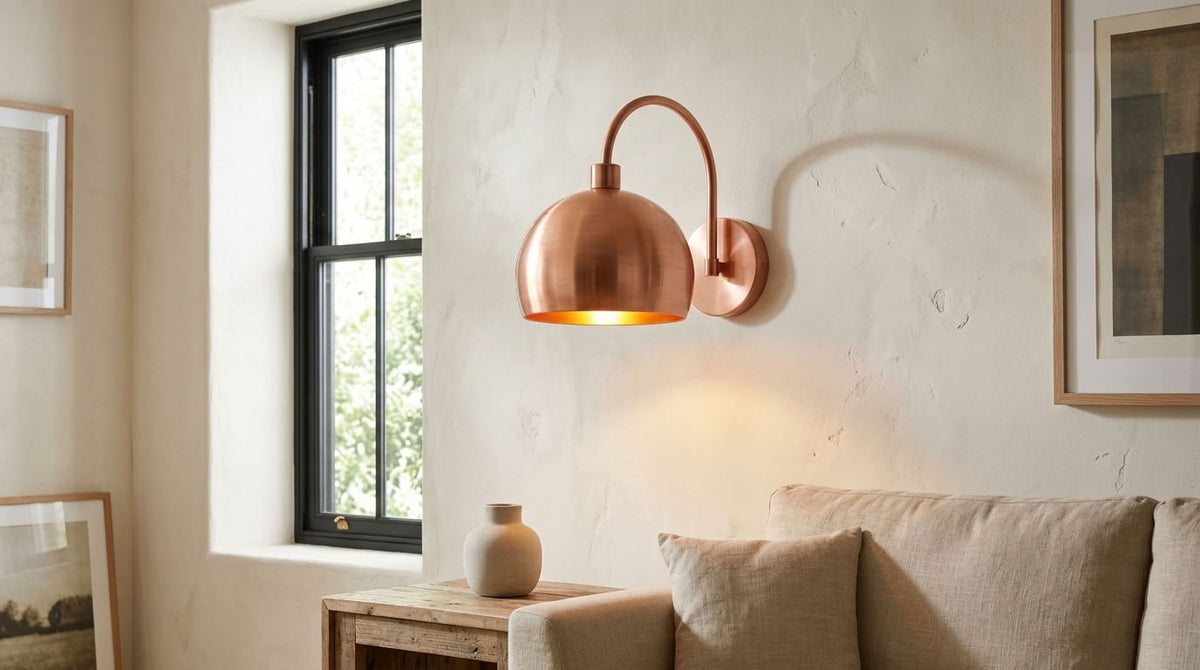 Modern smooth copper dome wall sconce with arched arm and warm light — view 3