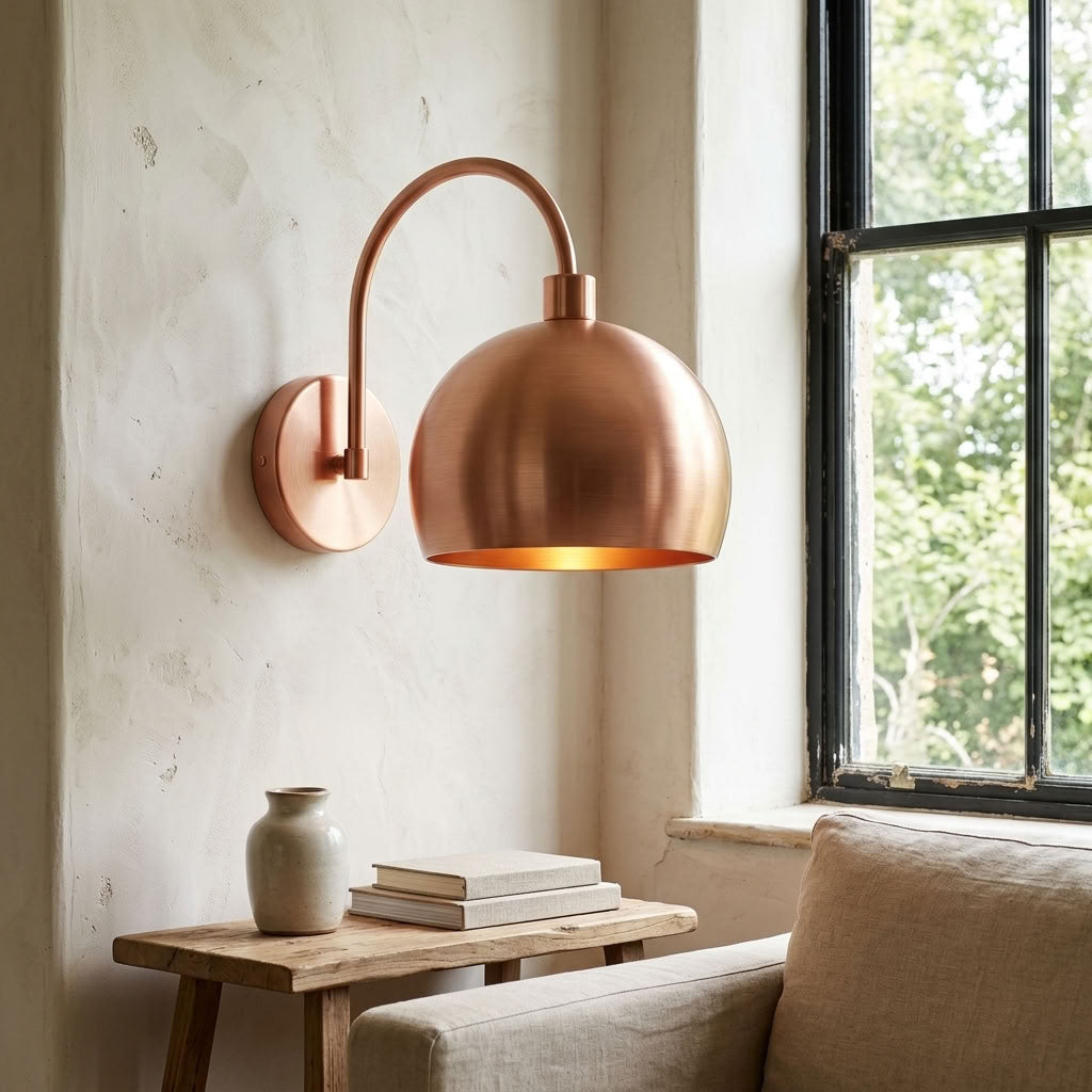 Modern smooth copper dome wall sconce with arched arm and warm light — view 4