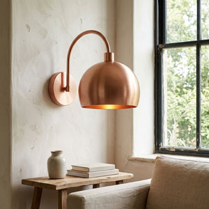 Modern smooth copper dome wall sconce with arched arm and warm light — view 4
